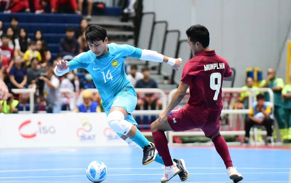 Chiến thắng của Thái Lan (áo đỏ) trước Malaysia (áo vàng) đã giúp đội tuyển futsal Việt Nam sớm đoạt vé vào vòng bán kết Giải futsal Đông Nam Á 2024. ẢNH: FAM 